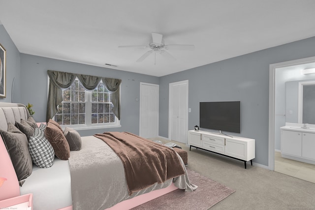 bedroom featuring connected bathroom, a ceiling fan, visible vents, light carpet, and baseboards