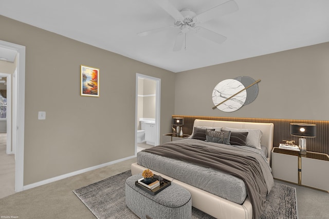 carpeted bedroom featuring ensuite bath, baseboards, and ceiling fan