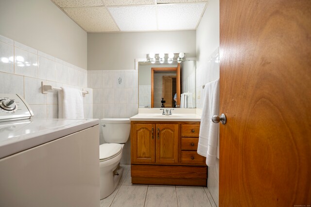 41 Seeley Rd, Trumbull, CT 06611 - bathroom featuring washer / clothes dryer, vanity, tile walls, a drop ceiling, and tile patterned flooring