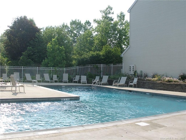 pool featuring fence and a patio area