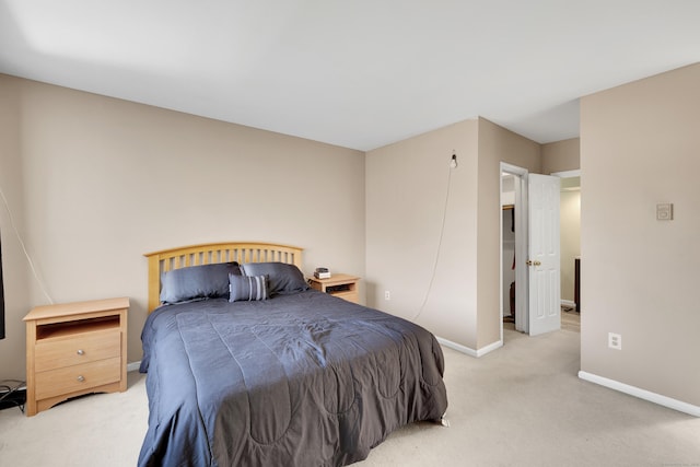 bedroom with light colored carpet and baseboards