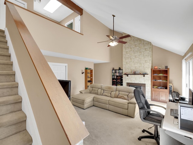 carpeted office space featuring beamed ceiling, a fireplace, high vaulted ceiling, and a ceiling fan