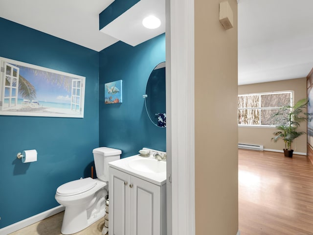 half bathroom featuring baseboards, toilet, wood finished floors, vanity, and baseboard heating