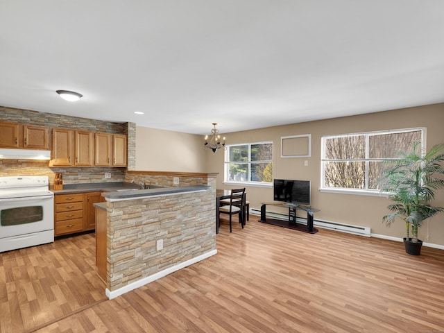 kitchen with white range with electric stovetop, light wood-type flooring, under cabinet range hood, a peninsula, and baseboard heating