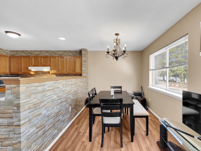 dining room featuring baseboards, a chandelier, and light wood-type flooring
