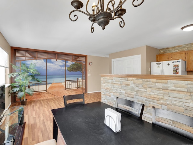 dining room with an inviting chandelier, baseboards, and wood finished floors
