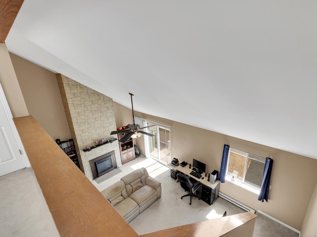 interior space featuring vaulted ceiling, a ceiling fan, a fireplace, baseboard heating, and carpet