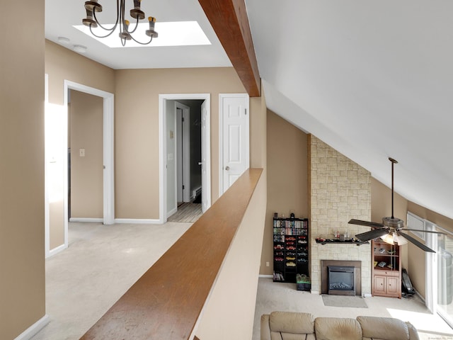 living room with high vaulted ceiling, carpet, baseboards, a fireplace, and ceiling fan with notable chandelier