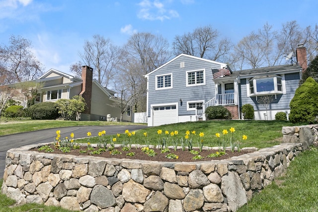 tri-level home with driveway, a front yard, and a garage