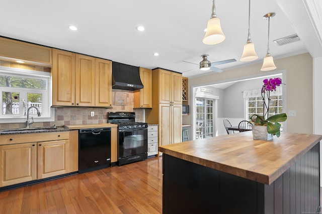kitchen featuring range hood, visible vents, a sink, black appliances, and butcher block countertops