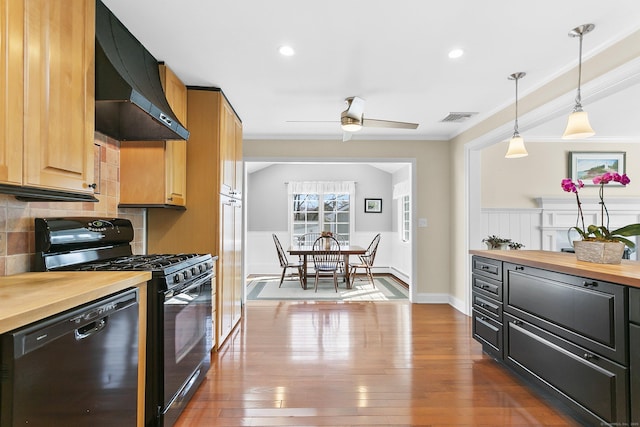 kitchen with visible vents, extractor fan, ceiling fan, butcher block counters, and black appliances