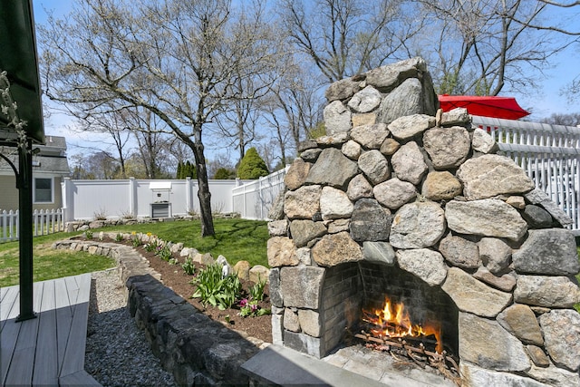 details with a fenced backyard and an outdoor stone fireplace