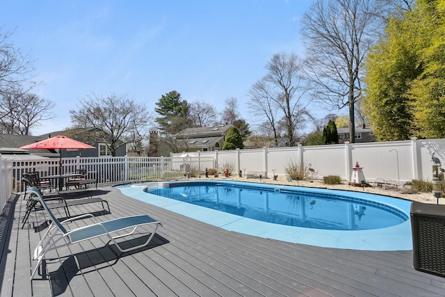 view of pool featuring a fenced in pool, a fenced backyard, and a deck