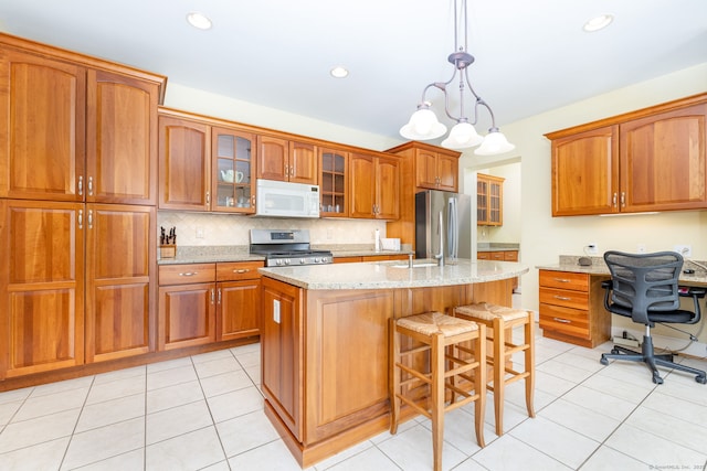 2 Pennington Dr Unit 2, Simsbury, CT 06070 - kitchen featuring appliances with stainless steel finishes, brown cabinetry, light stone countertops, a center island with sink, and recessed lighting