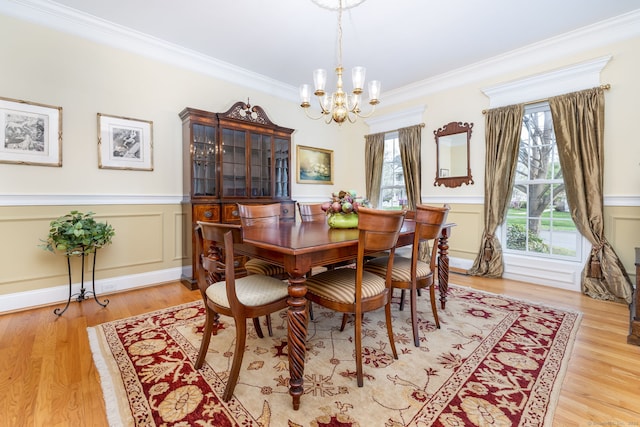2 Pennington Dr Unit 2, Simsbury, CT 06070 - dining space featuring a chandelier, crown molding, a wainscoted wall, light wood-style floors, and a decorative wall