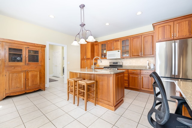 2 Pennington Dr Unit 2, Simsbury, CT 06070 - kitchen with stainless steel appliances, a sink, brown cabinets, tasteful backsplash, and light stone countertops