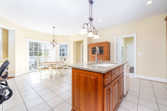2 Pennington Dr Unit 2, Simsbury, CT 06070 - kitchen featuring a sink, light tile patterned floors, light stone countertops, brown cabinetry, and baseboards