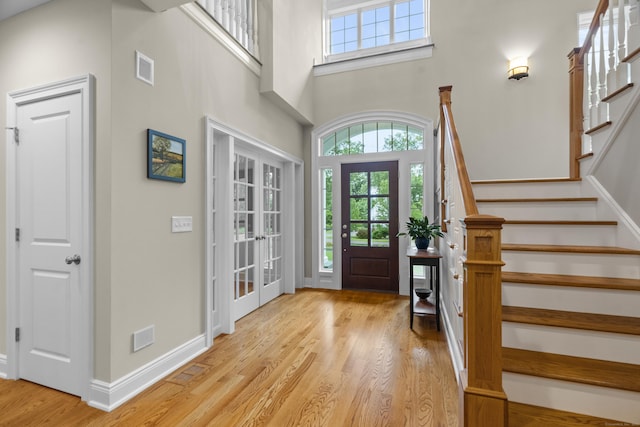 301 Fox Hopyard Rd, East Haddam, CT 06423 - entryway featuring light wood-type flooring, stairway, a towering ceiling, and french doors
