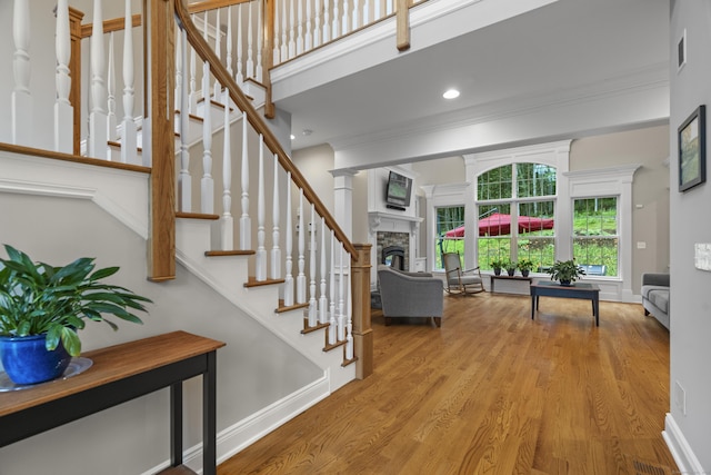 301 Fox Hopyard Rd, East Haddam, CT 06423 - staircase featuring a stone fireplace, wood finished floors, crown molding, and recessed lighting