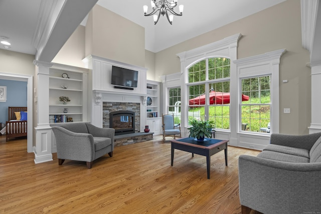 301 Fox Hopyard Rd, East Haddam, CT 06423 - living area featuring a high ceiling, a stone fireplace, a chandelier, and light wood-style flooring