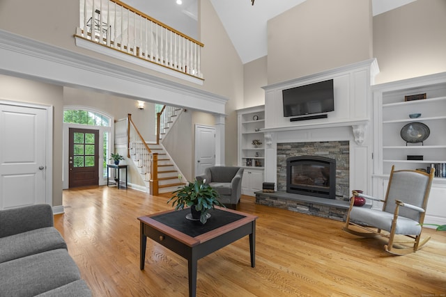 301 Fox Hopyard Rd, East Haddam, CT 06423 - living area featuring high vaulted ceiling, stairs, light wood finished floors, a fireplace, and built in shelves