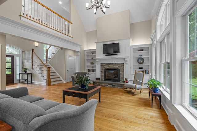 301 Fox Hopyard Rd, East Haddam, CT 06423 - living area with high vaulted ceiling, a chandelier, stairway, a fireplace, and light wood-style flooring