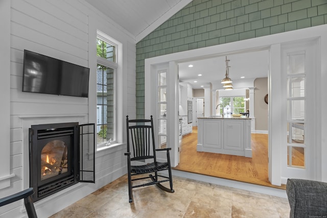 301 Fox Hopyard Rd, East Haddam, CT 06423 - living area with vaulted ceiling, plenty of natural light, a warm lit fireplace, crown molding, and decorative columns