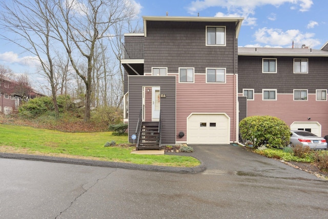 view of front of house with a front yard, driveway, and a garage