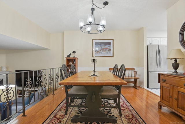 dining room featuring light wood-style floors and a notable chandelier