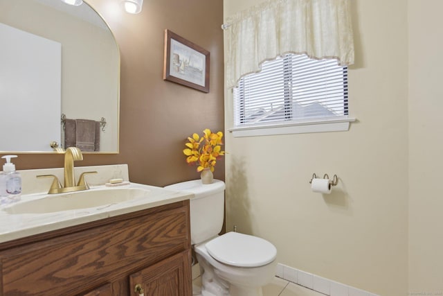half bath with toilet, vanity, baseboards, and tile patterned flooring