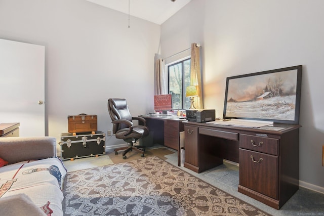 office space featuring baseboards, high vaulted ceiling, and light colored carpet
