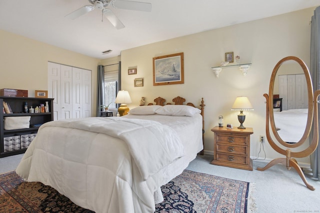 carpeted bedroom with visible vents, a closet, baseboards, and ceiling fan