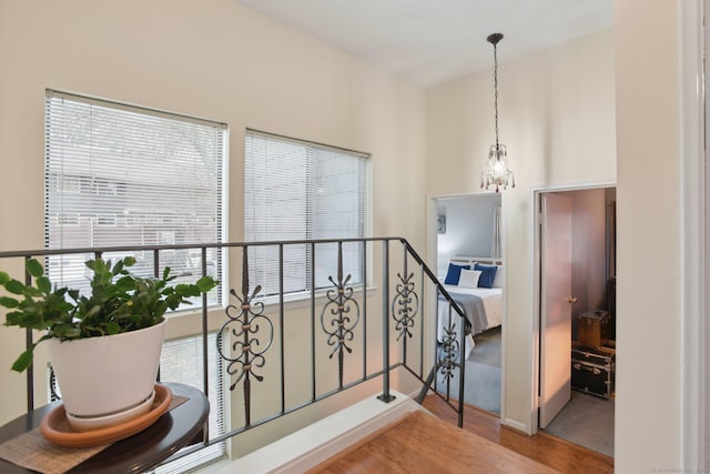stairs featuring a chandelier and wood finished floors