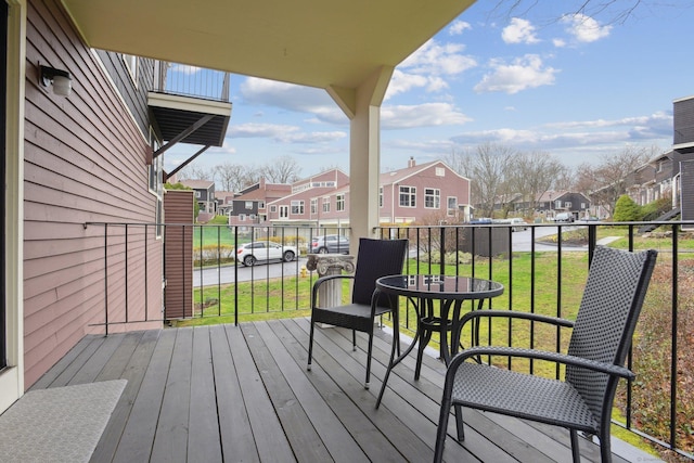 wooden deck with a residential view and a lawn
