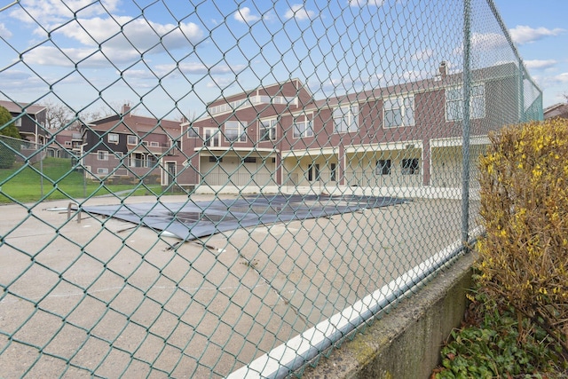 view of sport court with a residential view and fence