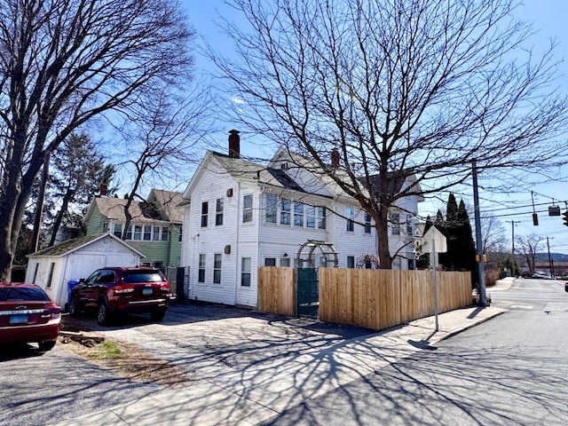 view of front of house featuring a chimney and fence