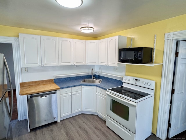 kitchen featuring a sink, white cabinetry, wood finished floors, and appliances with stainless steel finishes