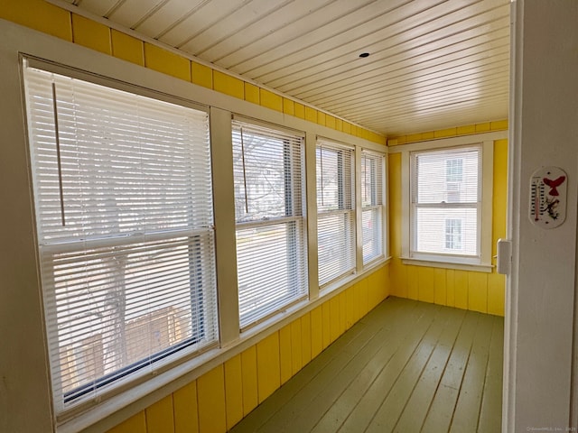 unfurnished sunroom with hardwood / wood-style flooring and wooden walls