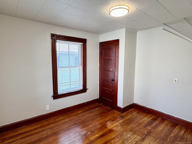 interior space featuring baseboards, ornamental molding, and hardwood / wood-style floors
