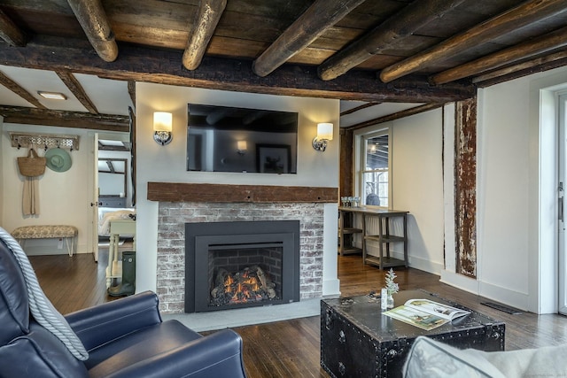 living room with beamed ceiling, a fireplace, dark wood-style floors, and visible vents