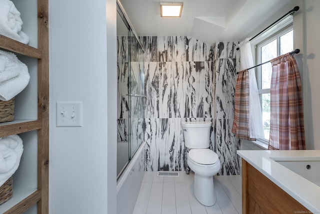 full bath with vanity, vaulted ceiling, enclosed tub / shower combo, tile patterned floors, and toilet