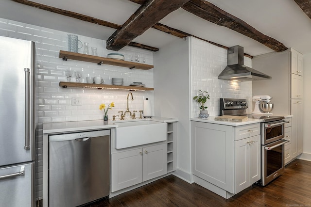 bar featuring stainless steel appliances, decorative backsplash, a sink, and wall chimney range hood