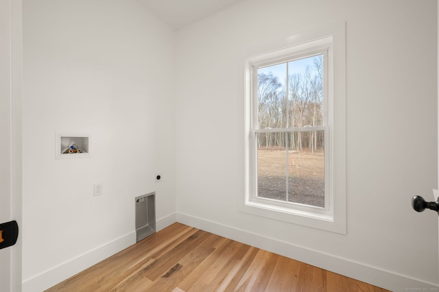 washroom with washer hookup, hookup for an electric dryer, laundry area, baseboards, and light wood-style floors