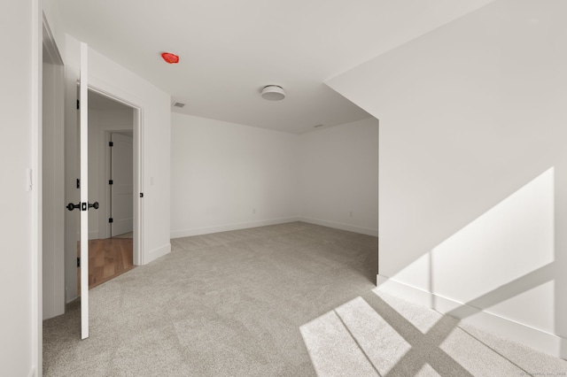 carpeted spare room featuring baseboards