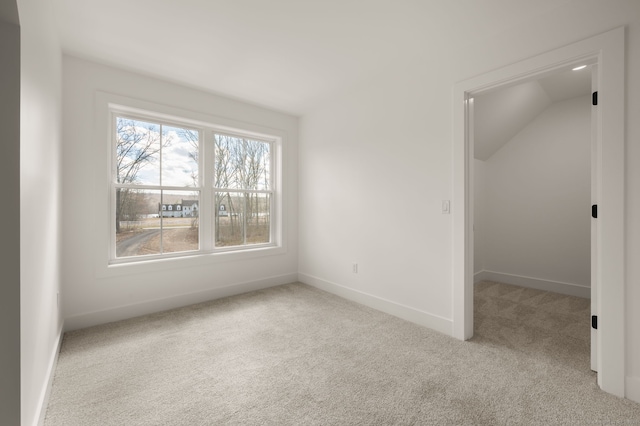 unfurnished bedroom featuring vaulted ceiling, baseboards, and carpet flooring