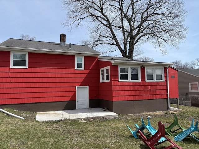133 Traverse St, Waterbury, CT 06704 - back of property featuring a patio area, a lawn, a chimney, and fence