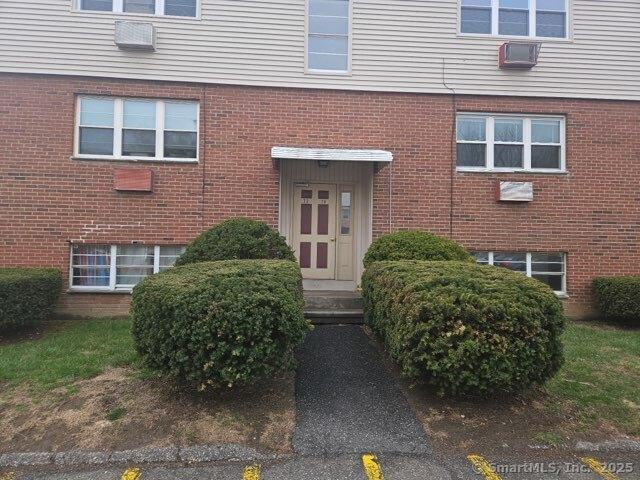 doorway to property featuring brick siding