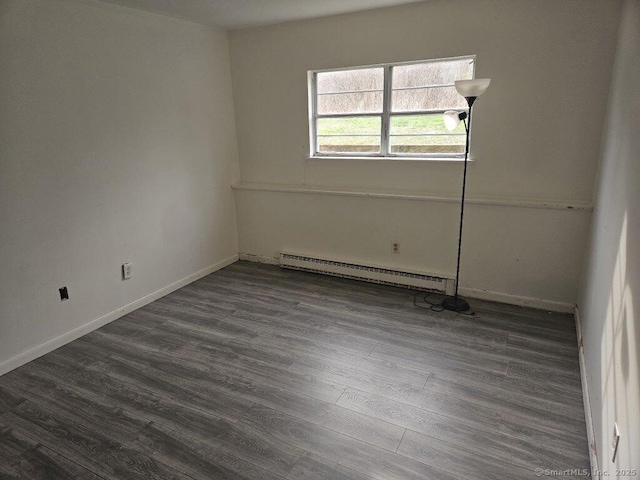 empty room with baseboards, baseboard heating, and dark wood-style flooring