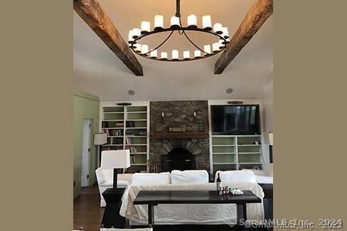253 Tophet Rd, Roxbury, CT 06783 - living room featuring wood finished floors, a stone fireplace, and a chandelier