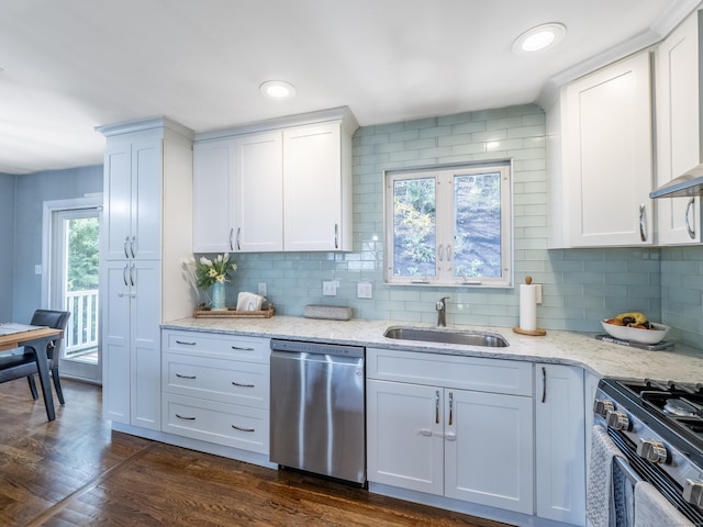 kitchen featuring white cabinets, stainless steel dishwasher, a sink, backsplash, and range with gas stovetop